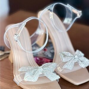 BCBGeneration Women's Sandals with Clear Straps and Silver Bow